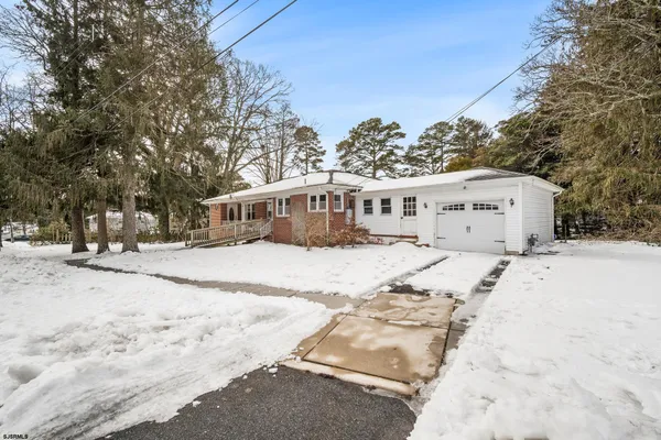 a view of a white house with a yard covered in snow