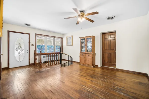 a living room with wooden floor and a window