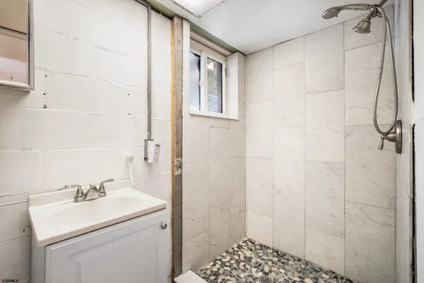 a bathroom with a sink a toilet and shower