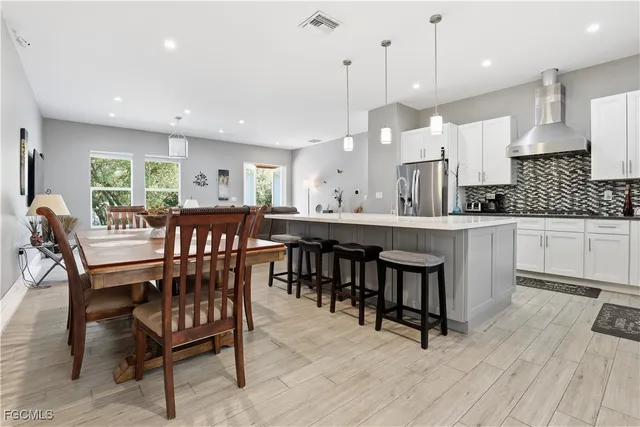 a dining area with a table chairs and a kitchen view