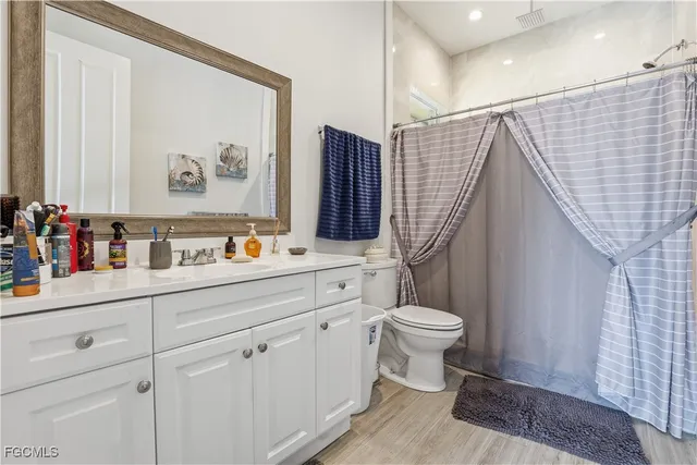 a bathroom with a sink a toilet and a shower curtain