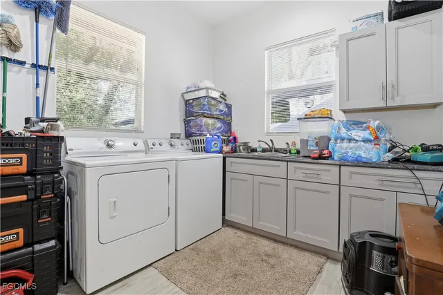 a utility room with cabinets washer and dryer