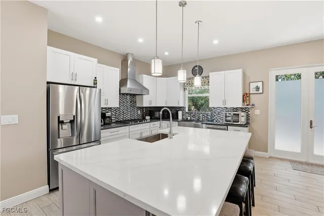 a kitchen with stainless steel appliances a sink a stove a refrigerator and cabinets
