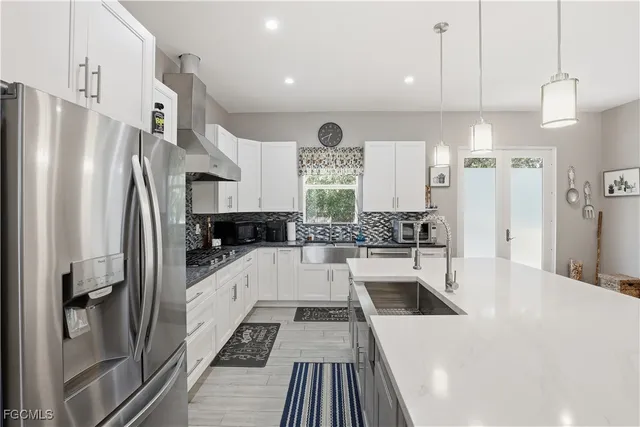 a large white kitchen with a refrigerator a oven and white cabinets