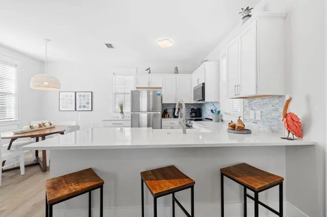 a kitchen with stainless steel appliances granite countertop a sink and a refrigerator