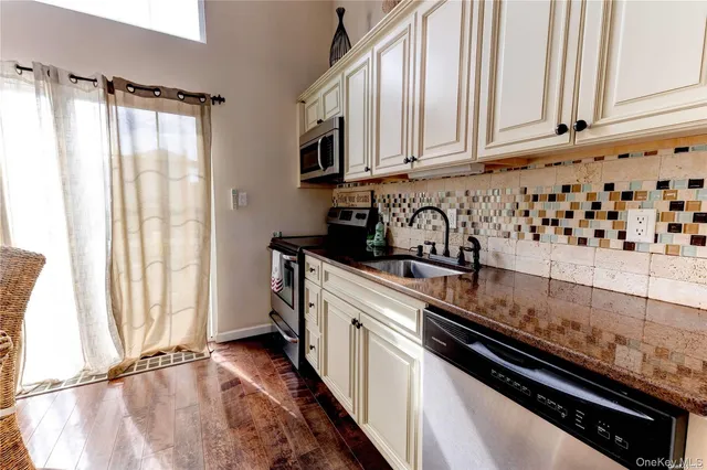 a kitchen with granite countertop a sink a stove and cabinets
