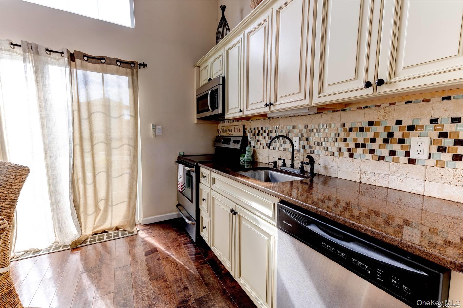 67 Vermont Street Long Beach, NY 11561 - Photo 11 of 26 a kitchen with granite countertop a sink a stove and cabinets