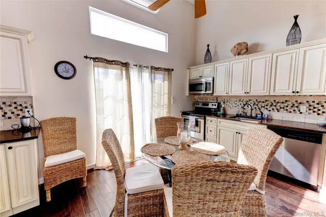 a kitchen with granite countertop a stove a sink dishwasher a dining table and chair with wooden floor