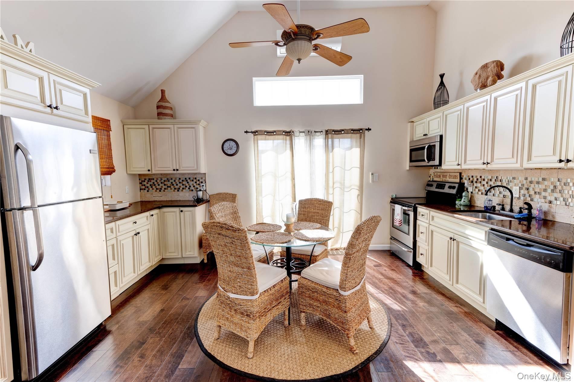 67 Vermont Street Long Beach, NY 11561 - Photo 14 of 26 a kitchen with stainless steel appliances granite countertop a refrigerator a stove a sink dishwasher and white cabinets with wooden floor