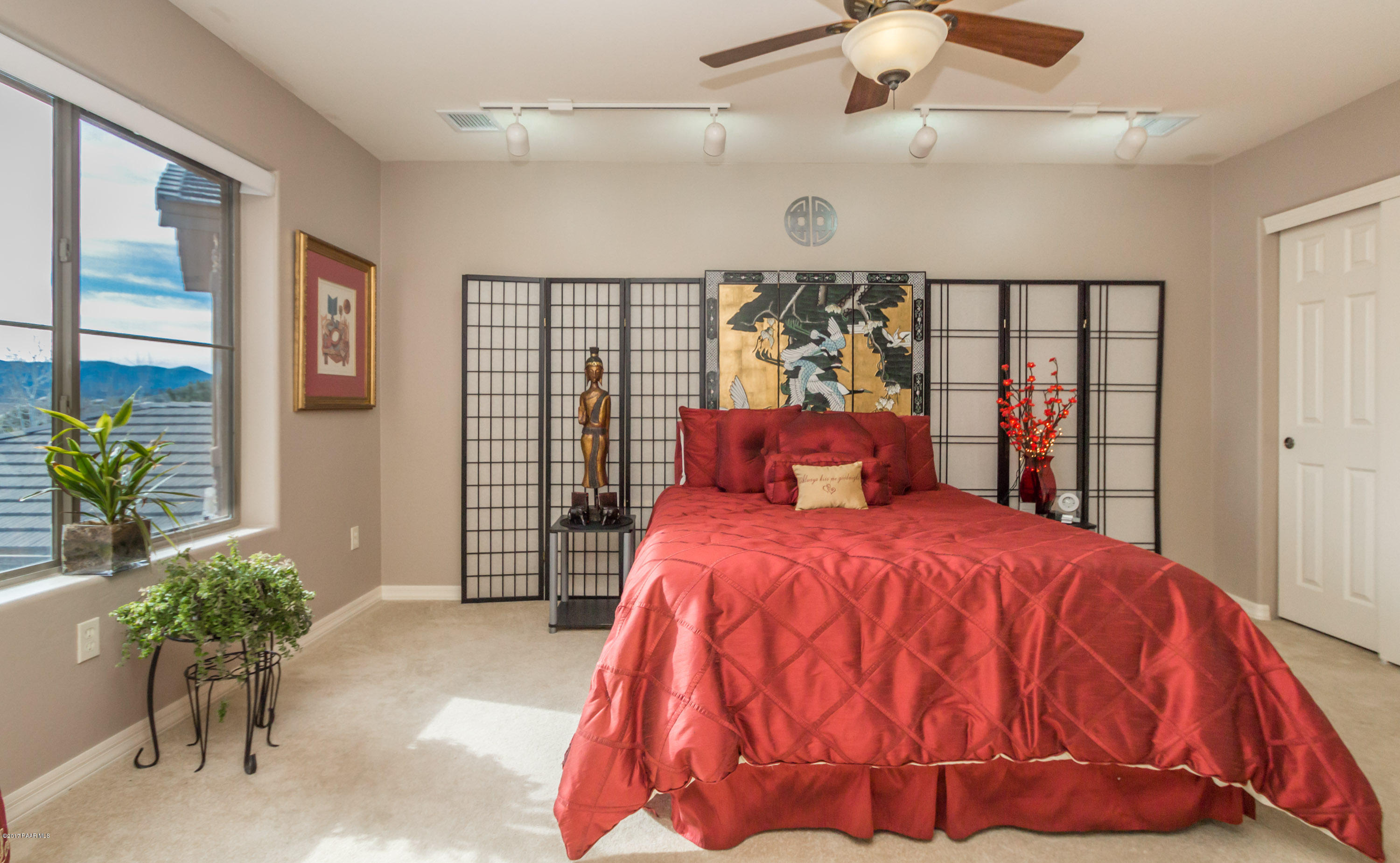 1256 Crown Ridge Drive Prescott, AZ 86301 - Photo 17 of 31 a bedroom with a large bed and a potted plant