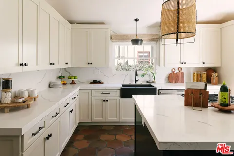 a kitchen with a sink a window and cabinets