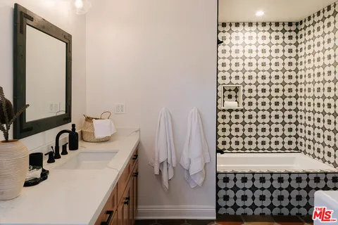 a bathroom with a granite countertop sink a toilet and bathtub