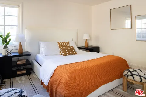 a living room with furniture and a refrigerator