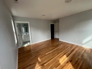 a view of a bedroom with wooden floor