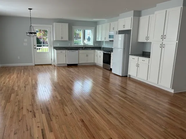a kitchen with stainless steel appliances a refrigerator and wooden floors