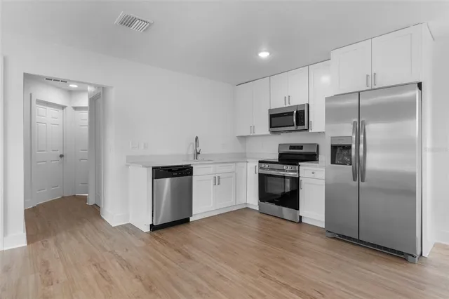 a kitchen with granite countertop a refrigerator and a stove top oven