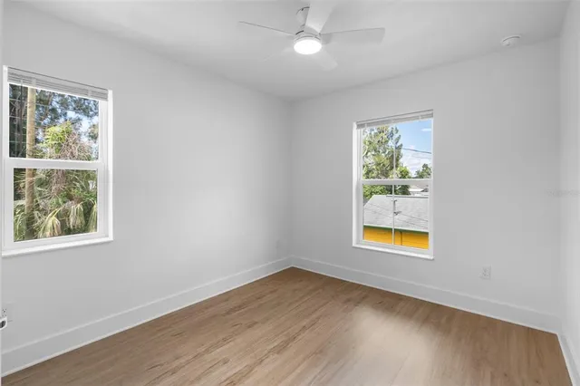 an empty room with window and wooden floor