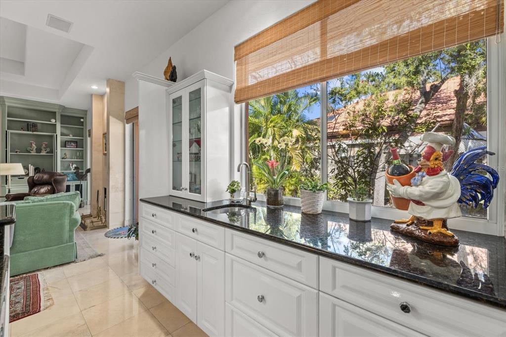 4939 Peregrine Point Way Sarasota, FL 34231 - Photo 19 of 57 a kitchen with kitchen island a counter space a sink and a large window