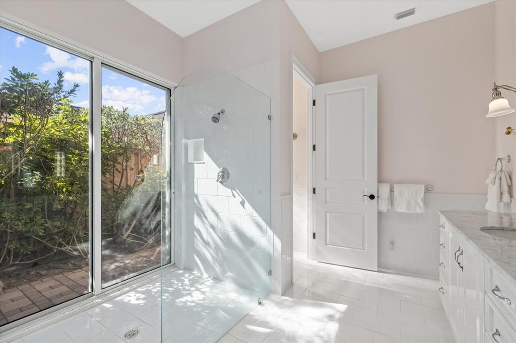 4939 Peregrine Point Way Sarasota, FL 34231 - Photo 39 of 57 a bathroom with a granite countertop sink a mirror and shower