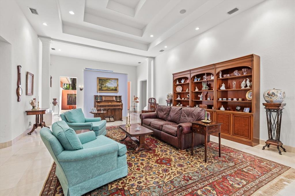 4939 Peregrine Point Way Sarasota, FL 34231 - Photo 10 of 57 a living room with furniture a rug and a bookshelf
