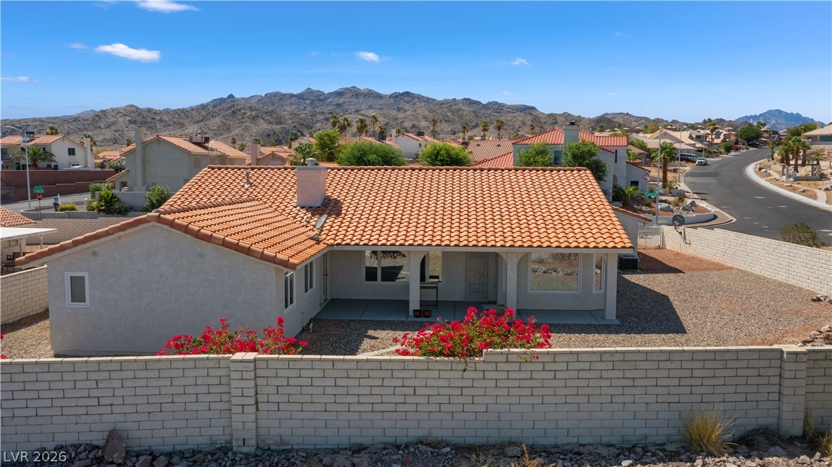 2055 Cholla Way Laughlin, NV 89029 - Photo 79 of 87 Red tile roof over a desert dwelling with a mountain backdrop.