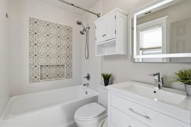 a bathroom with a bathtub toilet sink vanity and mirror