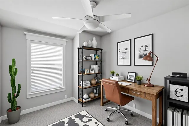 a view of a workspace with furniture and a window