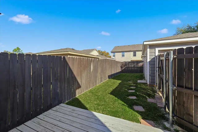 a view of a backyard with wooden fence