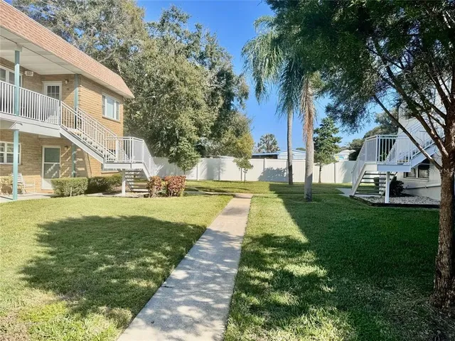 a view of house with garden and tall trees