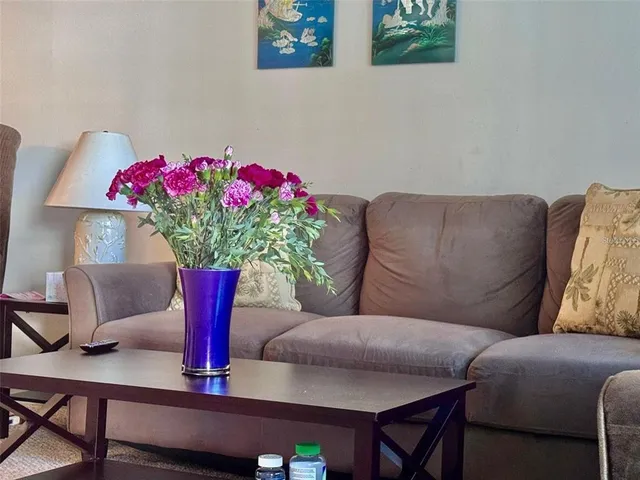 a living room with furniture flowers and a potted plant