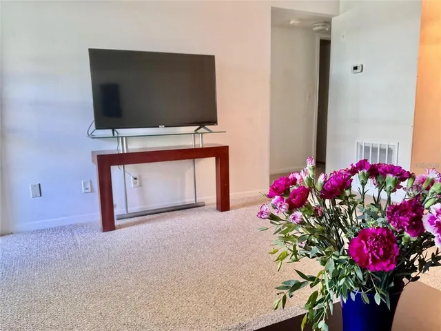 a living room with flowers and a flat screen tv