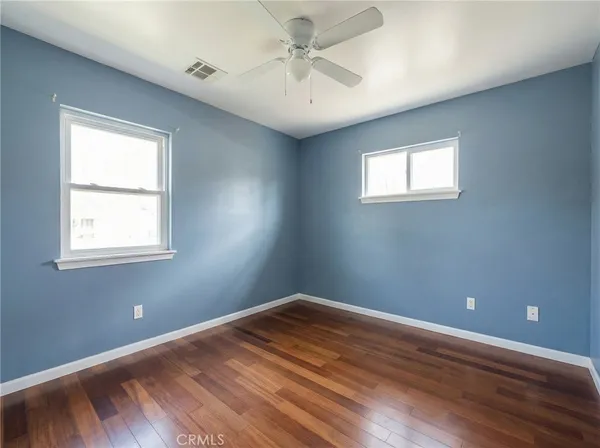 a view of a room with wooden floor and windows
