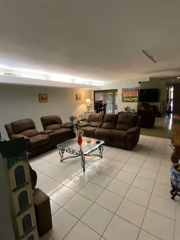 a living room with furniture and a gym machine