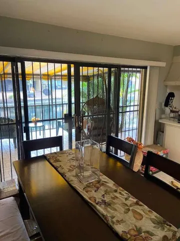 a living room with large pool table and glass windows