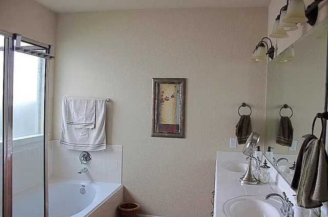 a bathroom with a tub sink and mirror
