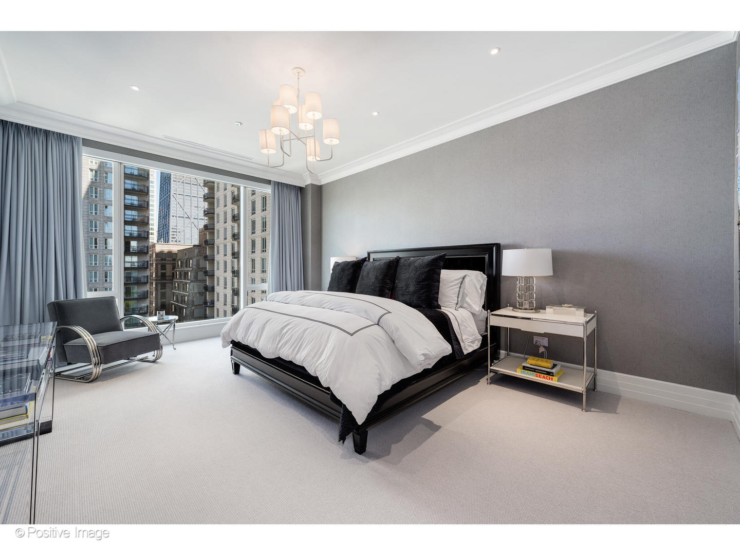 9 West Walton Street, Unit 1501 Chicago, IL 60610 - Photo 24 of 37 a bedroom with a bed and a chandelier