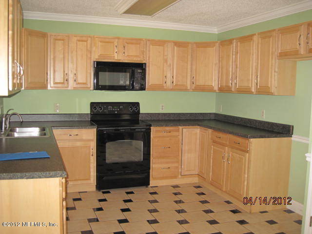 12333 Raleigh Ridge Drive Jacksonville, FL 32225 - Photo 2 of 5 a kitchen with granite countertop a stove a sink and a microwave