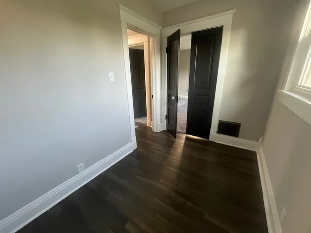 an empty room with wooden floor and closet