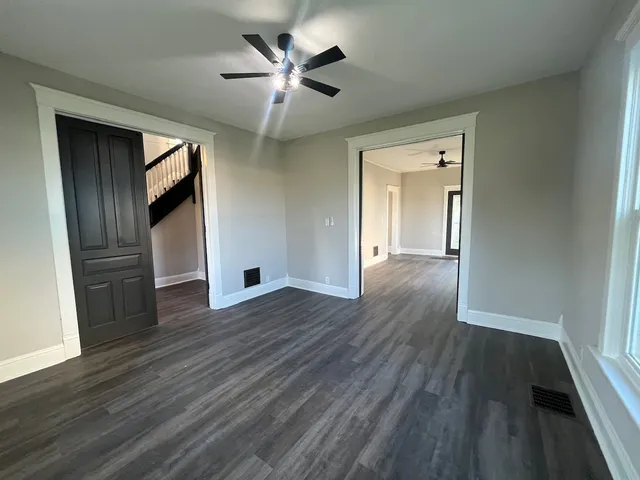 an empty room with wooden floor and windows