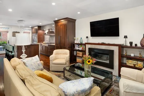a living room with furniture a flat screen tv and a fireplace