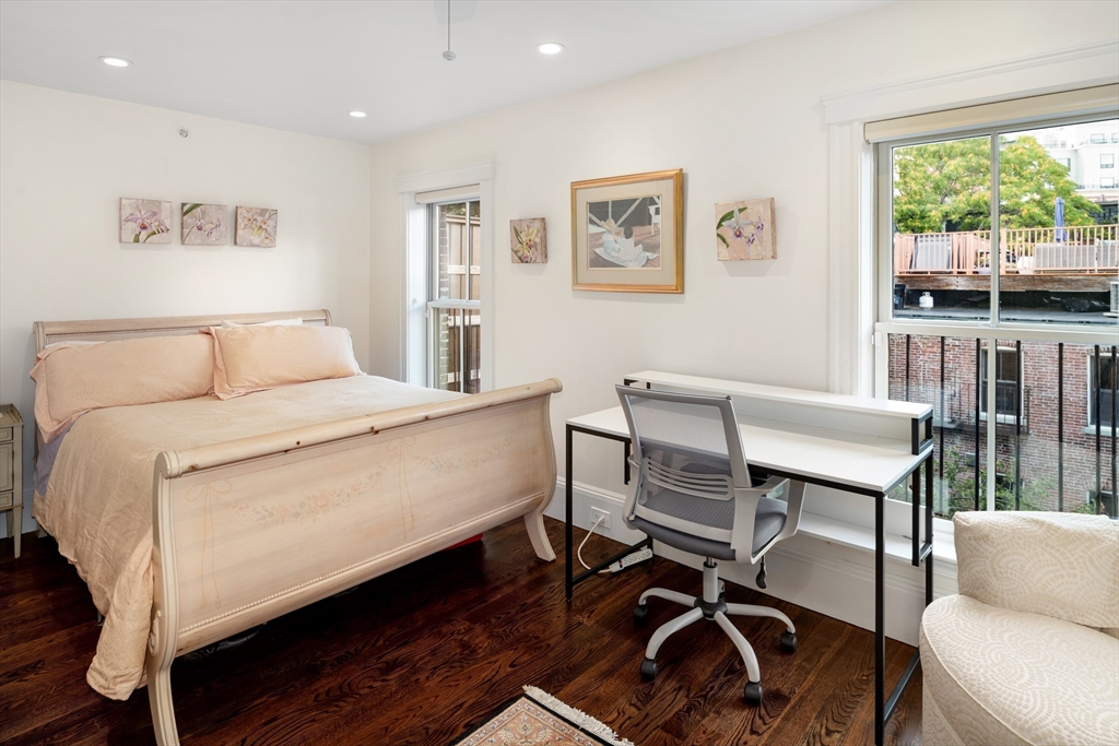 109 Appleton Street Boston, MA 02116 - Photo 27 of 30 a room with a bed a desk and chair with wooden floor