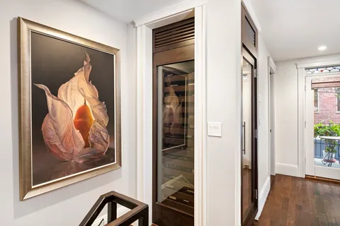 a view of a hallway with wooden floor and windows