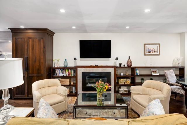a living room with furniture a fireplace and a flat screen tv
