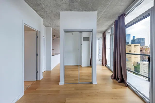 a view of a hallway with wooden floor and a living room