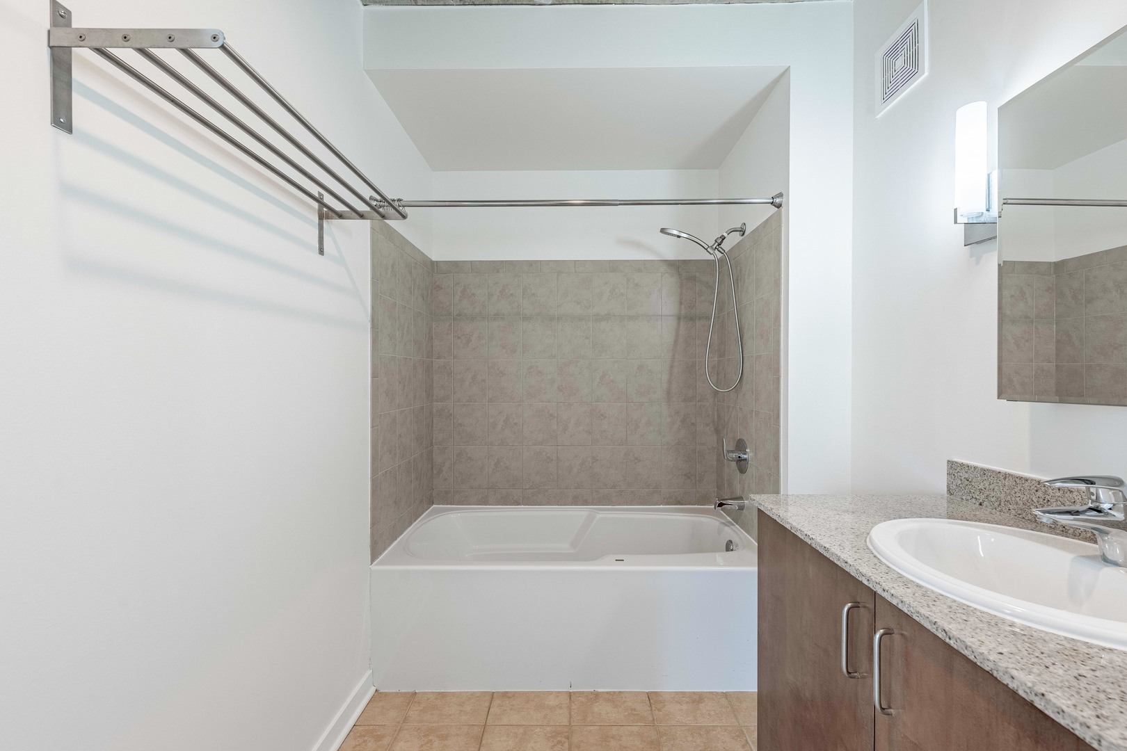 611 South Wells Street, Unit 2301 Chicago, IL 60607 - Photo 24 of 25 a bathroom with a granite countertop bathtub shower sink vanity and mirror