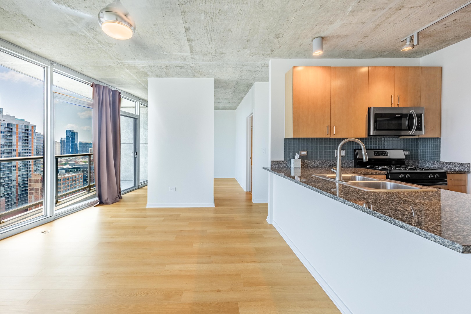 611 South Wells Street, Unit 2301 Chicago, IL 60607 - Photo 7 of 25 a view of a kitchen with a sink and a large window