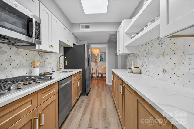 a kitchen with stainless steel appliances granite countertop a stove and a sink