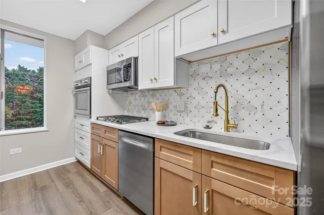 a kitchen with stainless steel appliances a sink a stove and cabinets