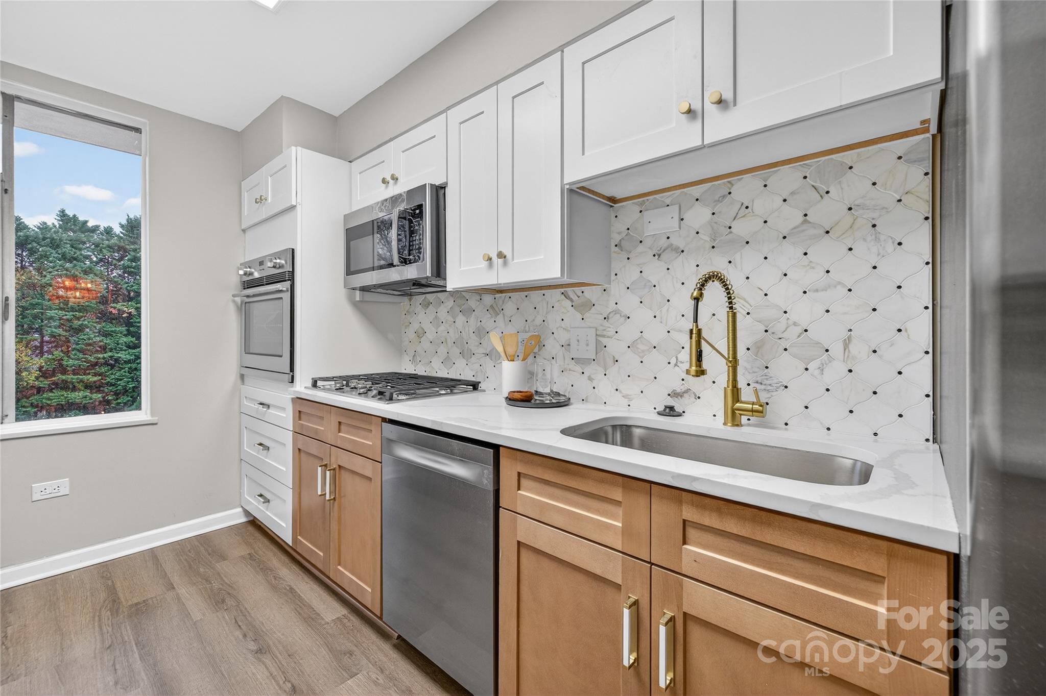 1300 Queens Road, Unit 409 Charlotte, NC 28207 - Photo 7 of 35 a kitchen with stainless steel appliances a sink a stove and cabinets