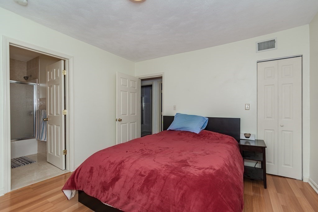 246 Haven Street, Unit 2 Reading, MA 01867 - Photo 16 of 23 a bed room with a bed and wooden floor